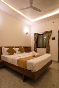a bedroom with a large bed with a ceiling fan at Sapphire Mansion in Alibag