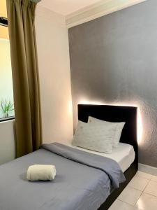 łóżko z białą poduszką na górze w obiekcie Andiana Hotel & Lodge - Kota Bharu City Centre w mieście Kota Bharu