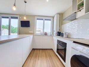 a kitchen with white cabinets and a counter top at T4 moderne CLIM sans vis à vis centre ville in Nîmes