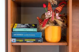 a book shelf with a vase and books at Casa Sara Lu Bagnu in Castelsardo