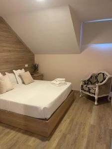 1 dormitorio con 1 cama grande y 1 silla en HOTEL apartamentos SEVEN ROOMS, en Punta Umbría