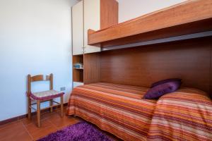 een slaapkamer met een stapelbed en een houten hoofdeinde bij Casa Sara Lu Bagnu in Castelsardo