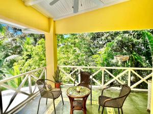 eine Veranda mit 3 Stühlen und einem Tisch auf dem Balkon in der Unterkunft Casa Amable by Ronnys Place in Manuel Antonio