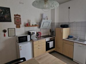 a small kitchen with a refrigerator and a microwave at Ferienwohnung in Flörsheim