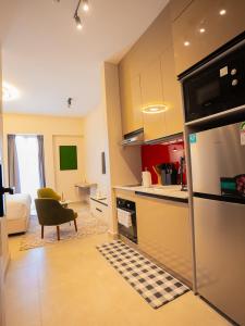 a kitchen with a refrigerator and a living room at Zarafa Suites in Nairobi