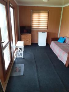 Cabana OTE Soft في سناجوف: غرفة نوم بسرير وثلاجة وطاولة