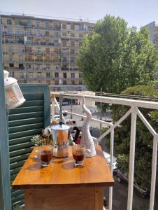 een tafel met twee glazen wijn op een balkon bij casa vacanze a casa di ciro in Napels
