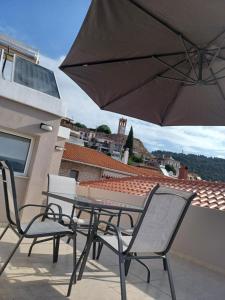 een tafel en stoelen op een balkon met een parasol bij Incanto Luxury Suites in Nafpaktos