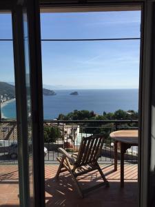 een stoel op een balkon met uitzicht op de oceaan bij Casa Limoneto in Noli