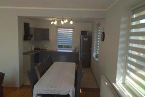 a kitchen with a table with chairs and a refrigerator at Wczasy u Ireny in Lubiatowo