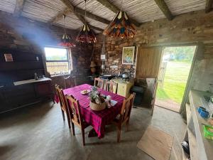 a dining room with a table and a kitchen at Kwaggaskop Farm Kliphuis in Dullstroom +26 photos