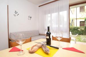 einen Tisch mit einer Flasche Wein und zwei Gläsern in der Unterkunft Comfy flat 80m from the beach - Beahost in Bibione