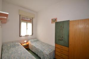 1 Schlafzimmer mit 2 Betten, einer Kommode und einem Fenster in der Unterkunft Comfy flat 80m from the beach - Beahost in Bibione