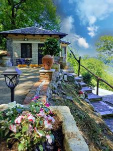 a garden with flowers in front of a house at The Mushroom Cottage in Anilio Pelion