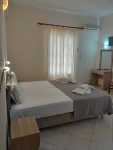 a bedroom with a large bed with a window at Barbara II in Agia Marina Aegina