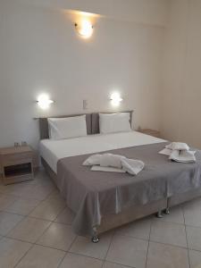 a bedroom with a large bed with two towels on it at Barbara II in Agia Marina Aegina