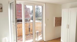 home2stay Worker House Feldstetten Kitchen,Wifi,Smart TV Parking *** في Laichingen: غرفة مع أبواب زجاجية منزلقة كبيرة مع شرفة