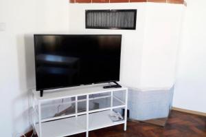 TV de pantalla plana en la parte superior de un puesto blanco en home2stay Worker House Feldstetten Kitchen,Wifi,Smart TV Parking ***, en Laichingen
