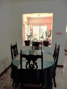comedor con mesa, sillas y ventana en BONI CHATEAU VACATION SPOT is a One Bedroom Self-contained Apartment For Travelers Needing To Be In Tune With Nature, en Discovery Bay