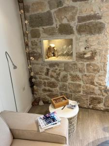 una sala de estar con una pared de piedra y una mesa. en Sea Pearl en Komiža
