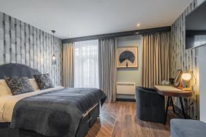 ein Schlafzimmer mit einem Bett und einem Schreibtisch in einem Zimmer in der Unterkunft Howfield Hotel in Merthyr Tydfil