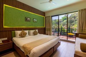 a bedroom with a large bed and a large window at Zaras Resort Khandala in Lonavala