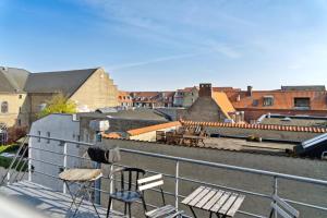 a balcony with chairs and a view of a train yard at Come Stay 2BR -Luxury Apartment 300 m from Magasin in Aarhus