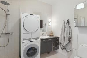 y baño con lavadora y lavamanos. en Come Stay 2BR -Luxury Apartment 300 m from Magasin, en Aarhus