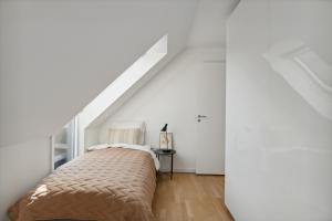 1 dormitorio con 1 cama en una habitación blanca en Come Stay 2BR -Luxury Apartment 300 m from Magasin, en Aarhus