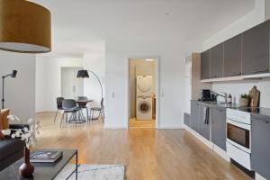 a kitchen and living room with a couch and a table at Come Stay 2BR -Luxury Apartment 300 m from Magasin in Aarhus