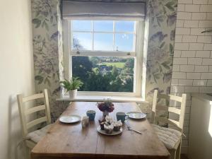 una mesa de madera en una habitación con ventana en The Mount Somerton Apartments - Somerset Private, Peaceful & 400 mtres from the village en Somerton