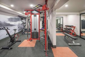 a gym with several treadmills and bikes in it at Ramada by Wyndham Cochrane in Cochrane