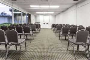 an empty room with chairs and a table in it at Travelodge by Wyndham San Francisco Airport North in South San Francisco