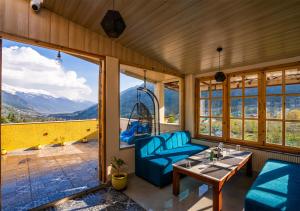 a room with a swing and a table and chairs at Moustache Manali in Manāli