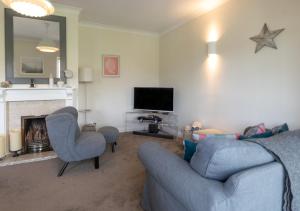 a living room with a couch and chairs and a television at The Haven in Snape