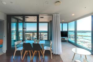 a dining room with a table and chairs and floor to ceiling windows at Magnificent SkyTower, Sea, Habour View in CBD in Auckland