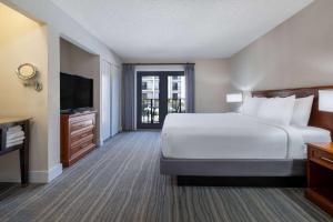 a large hotel room with a bed and a television at Wyndham Boca Raton Hotel in Boca Raton