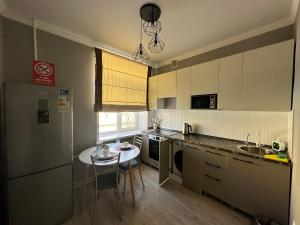 a kitchen with a small table and a kitchen with white cabinets at 1 комн.квартира in Balqash