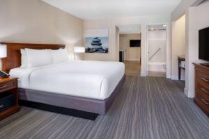 Habitación de hotel con cama grande y baño. en Wyndham Boca Raton Hotel, en Boca Raton