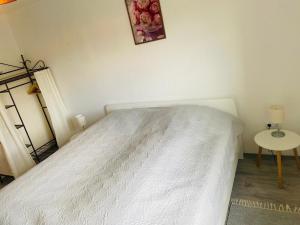 a bedroom with a white bed and a table at Rhönluft 1 in Wildflecken