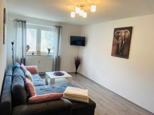 a living room with a couch and an elephant painting on the wall at Rhönluft in Wildflecken