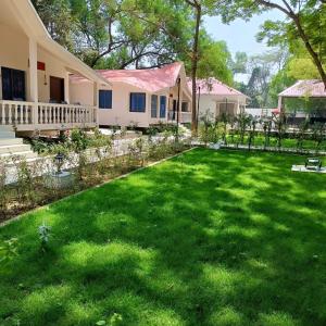 a yard of a house with a green lawn at SHANTINIKETAN RETREAT, BOLPUR in Shānti Niketan