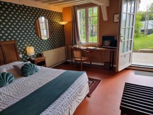 a bedroom with a bed and a desk and window at Le Relais Des Dalles - Hôtel & Restaurant in Sassetot-le-Mauconduit
