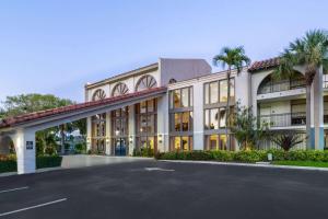 Un edificio con un estacionamiento enfrente. en Wyndham Boca Raton Hotel, en Boca Raton