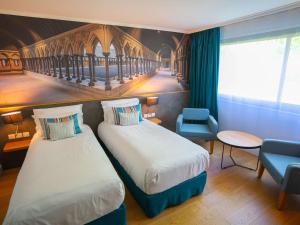 Ein Bett oder Betten in einem Zimmer der Unterkunft Mercure Mont Saint Michel