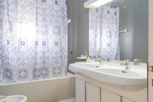 a bathroom with a sink and a shower curtain at Appartamento Solatio con 3 camere a Presicce in Presicce