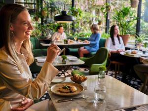 een vrouw aan een tafel met een bord eten bij Sofitel Legend The Grand Amsterdam in Amsterdam