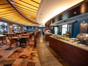 ein Restaurant mit Tischen und Stühlen und einem Buffet in der Unterkunft Mercure Mont Saint Michel in Le Mont Saint Michel