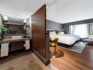 a hotel room with a bed and a bathroom at Sofitel Bogota Victoria Regia in Bogotá