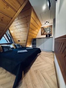 Un dormitorio con una cama grande en una habitación con techos de madera. en Willa Wysoka, en Zakopane